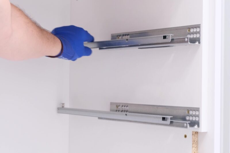 prikaz osobe koja montira klizače na policu